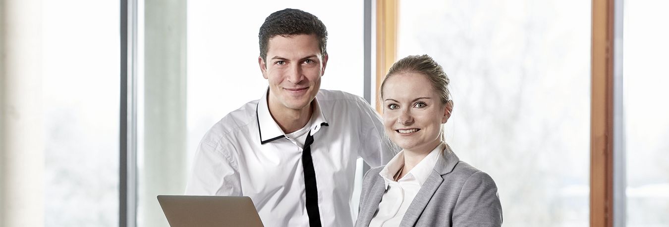 An employee stands in front of a laptop